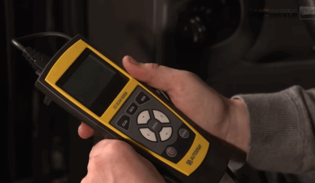 OBD-II scanner connected to car diagnostic port reading ABS codes