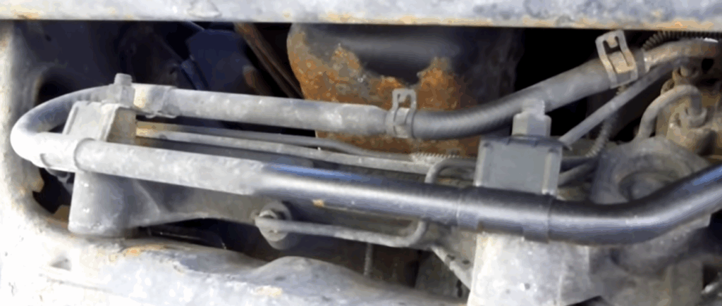 Image showing the removal of the return line on a car for flushing power steering fluid