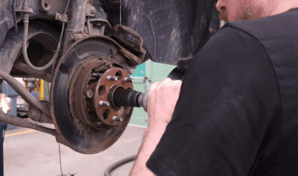 a mechanic removing a failing wheel bearing