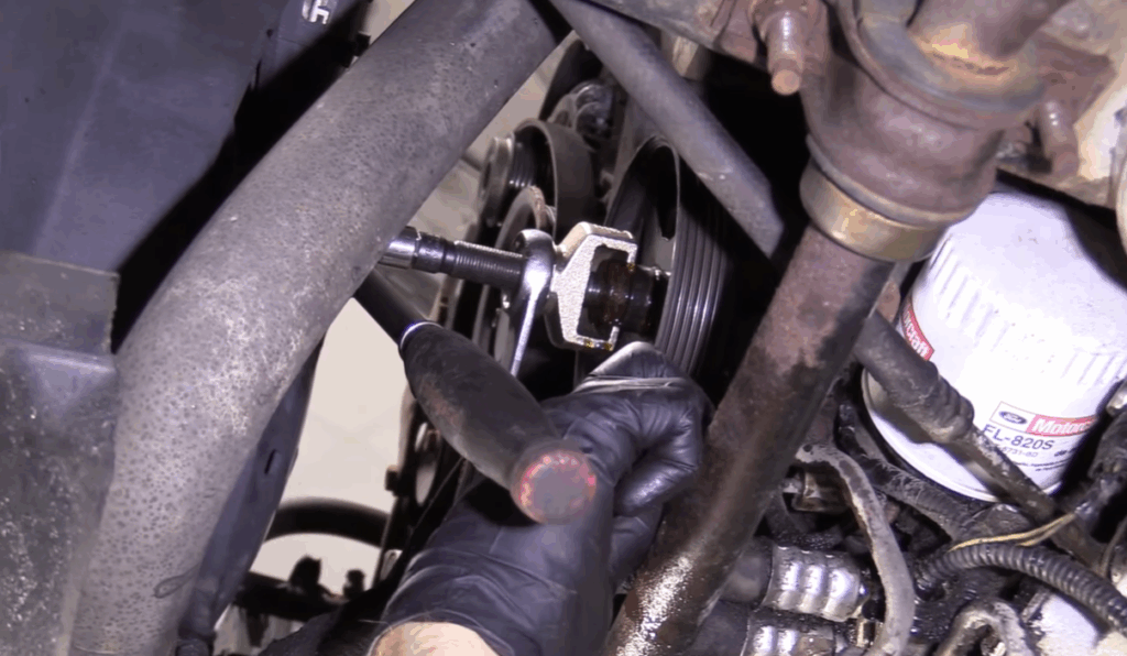 Image showing a mechanic tightening loose connections when fixing power steering leak